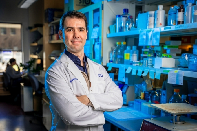 Dr. DeViito standing in a lab with his arms crossed